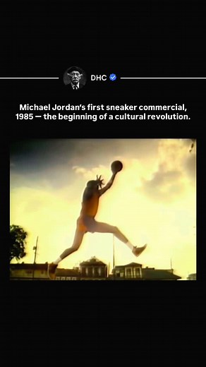 DHC | History, Entertainment & News on Instagram: "In 1985, rookie Michael Jordan debuted his first signature sneaker, the Air Jordan 1. At the time, signature shoes for players were rare—but these changed everything. The bold black-and-red “Banned” colorway defied NBA rules, sparking controversy, hype, and instant cultural impact. What started as a rookie’s shoe quickly grew into a movement, transforming basketball sneakers into fashion statements. This first commercial marked the launch of wha