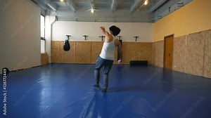 Young man shadow boxing coaches in the hall of MMA