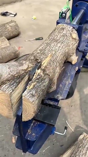 splitting a wood log using a hydraulic wood splitter machine for traditional woodworking carpentry