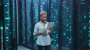 African american female engineer working with digital tablet in server room database. Smiling woman specialist staying at high tech data center internet complex.