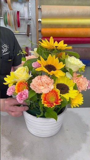 【A birthday celebration flower arrangement featuring yellow, orange, and a touch of pink】