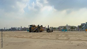sand cleaning machine with a roller stamp that leave pattern on the sand, beach of Dubai, UAE