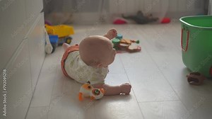 Baby exploring all around the house, 7 month old baby boy crawling, touching everything. Baby learning to crawl and play on the floor with a toys.