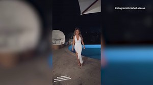 Chrishell Stause struts her stuff in a plunging white gown by the pool at night
