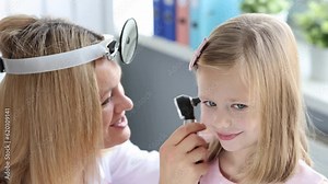 ENT doctor examining little girl ear using otoscope 4k movie slow motion. Treatment of exudative otitis media in children concept