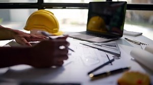 lose up of hands working and calculations estimate for cost and materials planning on paperworks and floor plan drawings about design architectural and engineering for houses and buildings.