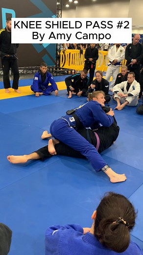 KNEE-SHIELD-GUARD PASS Amy Campo’s Knee-Shield Pass — Pressure Precision At Jiu-Jitsu Con 2024, Amy Campo showed how to dismantle one of the toughest defenses in modern BJJ — the knee-shield guard — with timing, base, and relentless top pressure. Key Details: - Collapse the knee shield with your hips, not your hands — turn their frame into a lever. - Clear the legs by rotating your base, staying heavy on the bottom knee. - Sky-hook the head to break posture and pin the upper body. - Circle the o