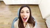 Close up of beautiful woman with mouth wide open at dentist, extreme...