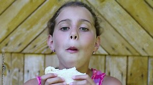 Girl eats bread. Beautiful girl eats slice of bread and smiles