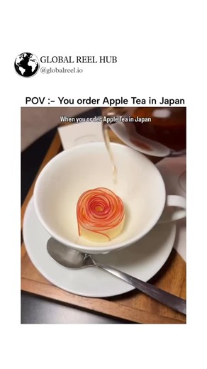GLOBAL REEL HUB™ on Instagram: "The post showcases a viral video of "apple blossom tea" from Tokyo's Oyoppi Cafe, where thin apple slices arranged in a spiral "bloom" into a rose-like shape upon pouring hot tea, demonstrating precise Japanese food presentation techniques. Originating in early 2025, this fusion of Turkish apple tea with innovative visuals has inspired global recreations, amassing millions of views across social media for its satisfying transformation. The blooming effect occurs a