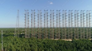 Aerial view of the DUGA radar station near the city of Chernobyl-2 among the forest. Exclusion Zone. Camera booming up. 4K drone footage.