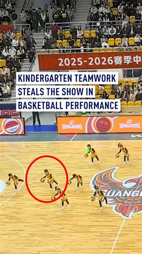 CGTN Europe on Instagram: "During a kindergarten basketball performance in south China’s Dongguan City, Guangdong Province,, a loose ball stole the show when it slipped from a young boy’s hands.⁣ ⁣ Instead of panicking, he stayed calm and continued the routine. As the formation shifted, a quick-thinking teammate in the front row smoothly kicked the ball back, allowing the boy to catch it perfectly and complete the performance — a great display of teamwork!⁣ ⁣ #Kindergarten #Teamwork #BasketballP