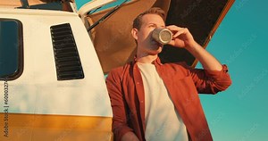 happy smiling handsome pensive man holding mug, cup, drinking coffee, tea, having rest, stop after long journey, trip, leisure adventure slow motion close up portrait traveler on road trip