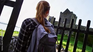 Exploring castle grounds as woman approaches castle