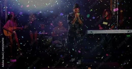 Confetti release starting as lead singer gripping mic, singing center stage while band celebrating