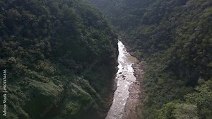 Downcutting river flows at base of Tamul Waterfall in Mexico forested jungle