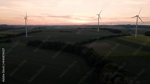 4K drone clip taking off over the countryside towards an aeolic part and wind turbines in Kehrig in Germany, during sunset