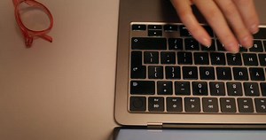 A person typing on a laptop computer