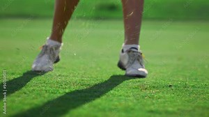 Lady golfer legs training wear white sneakers at country club course grass field
