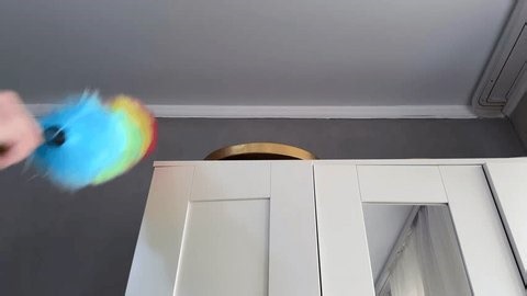 clip-4007597133-woman-cleaning-house-wipes-dust-off-wardrobe