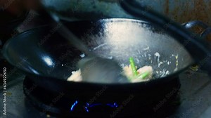 4K Cinematic cooking footage of a Thai chef cooking Thai food in a wok in a restaurant kitchen in Thailand