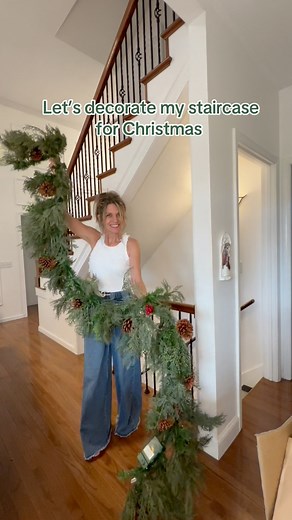 Decorating your staircase with beautiful Christmas garland can really warm up your home for Christmas. i’ve never been a fan of the trending Norfolk Garland. A beautiful Cypress cedar garland feels more realistic . I love the rich, dark green and the airy feel. The pinecones and berries add a natural element. The big Xl red velvet bows add the perfect touch.#Christmasgarland. #christmasstaircase #Christmas | Gilla Leigh Home Designs