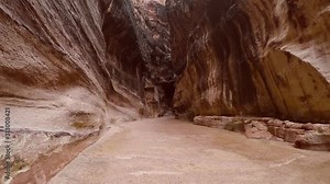 POV: Cinematic shooting of sliding along the gorge of the Siq canyon. Camera slides along the Al Siq Canyon near the Al Khazneh Treasury. Walking Inside Canyon in Ancient City of Petra in Jordan.