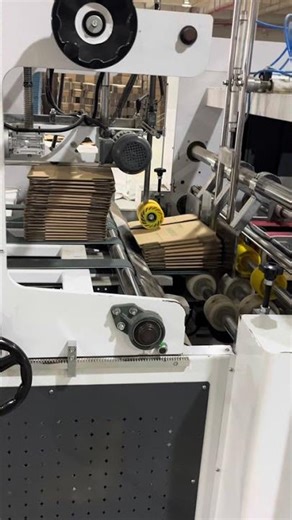 A clear view of the automated cardboard box production process in one continuous shot.