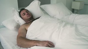 Man sleeping and waking up in bed