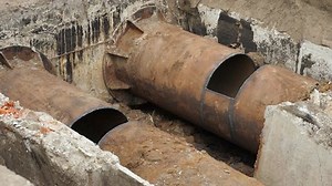 Heating pipe repair underground. Insulated steel pipeline in deep trench rust rusted. Reconstruction or replacement