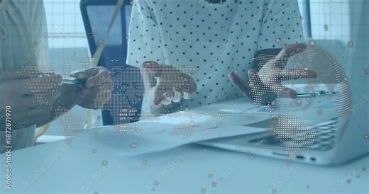 Coworkers reviewing business report pointing, marking edits under transparent world-map overlay