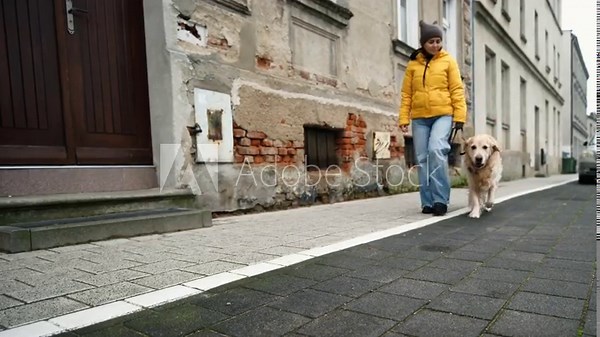 Woman Walking Dog On A Leash Along The Street In The Old Historical Part Of A European City
