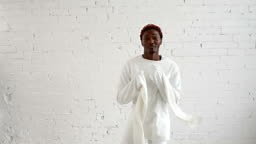 An insane black man in his forties wearing a straitjacket dance and...