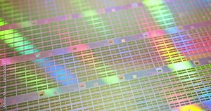 A close-up view of a silicon wafer's microprocessor circuit layout. The semiconductors or central processing unit CPU microchips are fabricated from a silicon wafer with patterned layers of materials.