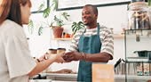 Barista, giving coffee cup and customer service at cafe counter with...