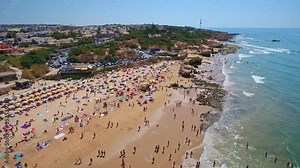 Aerial photography of the coast, the beaches of Gale in Portugal. Tourists are resting. The movement is parallel to the shore.