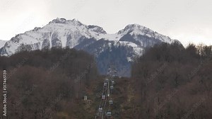 Krasnaya Polyana, Russia. December 2019: funiculars ascend a mountain with a snow-capped peak