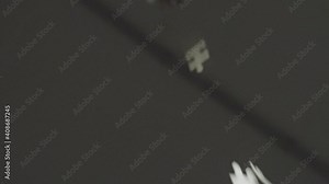 White puzzle pieces falling down and spinning in slow motion behind a gray background. Falling in and out of focus with shallow depth of field from the ceiling. Stock Video