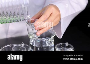 Scientist conducts experiment with beakers and chemicals