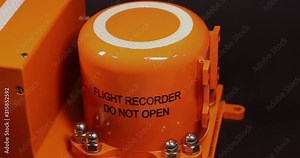Aircraft flight data recorder on black background.