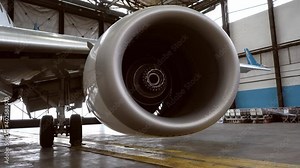 Airplane turbine close-up. Aircraft repair in the hangar. Engine, blades. Mechanism. Passenger airplane close-up disassembled. Plane details.