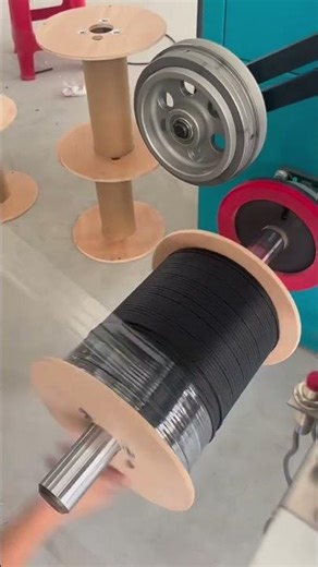 Industrial machine winding black cable neatly onto a rotating spool#popular #cnc #machine #machines