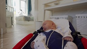 Baby sleeping in rocking chair while mom does household chores, 1.5 month old infant in baby bouncer. High quality 4k footage