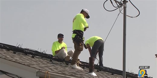 Former NFL, Iowa football player helps install solar panels on Iowa City Bike Library