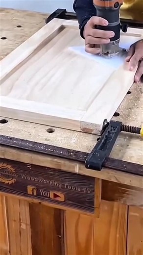 shaping a light wooden panel precisely using a handheld router tool to create decorative borders