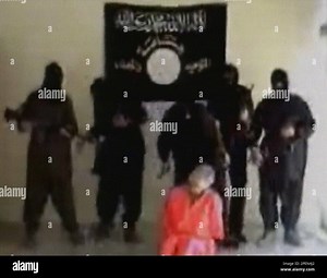 Masked men, including one with a knife, centre, approach a man identified as American construction contractor Eugene Armstrong, moments before he was beheaded in Iraq, in this image made from video, Monday Sept. 20, 2004. The militant group led by Jordanian terror mastermind Abu Musab al-Zarqawi claimed responsibility for the slaying and said another hostage, either another American or a Briton held by the group will be killed in 24 hours unless all Muslim women prisoners are released from U.S. 