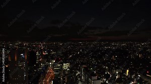 TOKYO, JAPAN : Aerial sunrise CITYSCAPE of TOKYO. View of rising sun and dramatic clouds around Shibuya. Japanese urban city life and nature concept. Long time lapse zoom in video, night to morning.