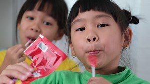 Cute little girl eating lollipop. Funny kid with lollipop candy. Child eating sweets.
