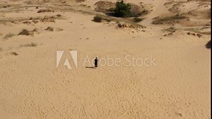 Aerial drone view of young woman enjoying walk in the largest desert in Europe, Ukraine, Oleshky Sands with Some bushes and Pine trees. Tourism place before Russian war in Ukraine. occupied territory. Stock Video