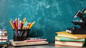 A background with an education theme that includes colorful textbooks, school supplies arranged across a desk, and a chalkboard that displays mathematical equations.